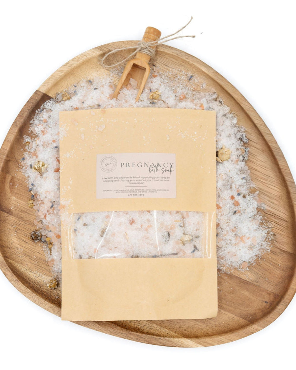 Pregnancy bath salts in a paper bag on a wooden tray with a white background
