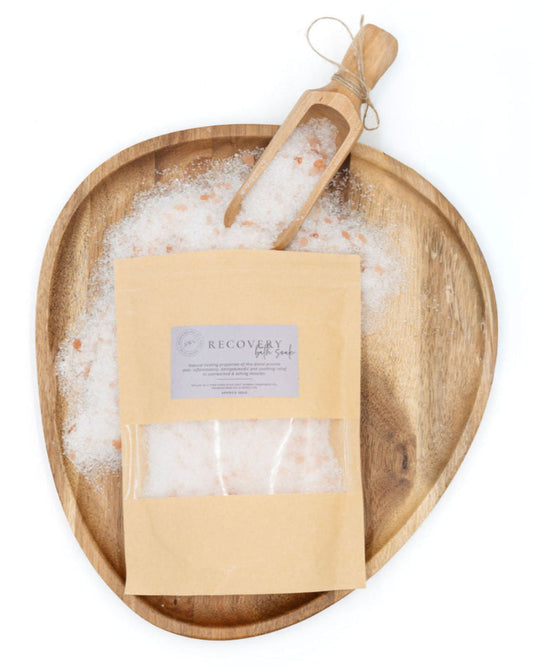 Bag of bath salts with a scoop on a wooden tray