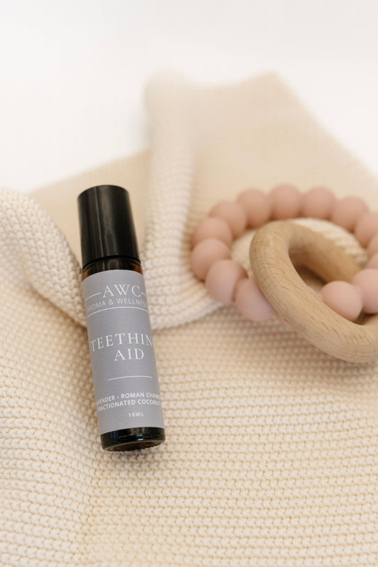 Roller bottle labeled 'Teething Aid' by AWC on a textured beige surface.